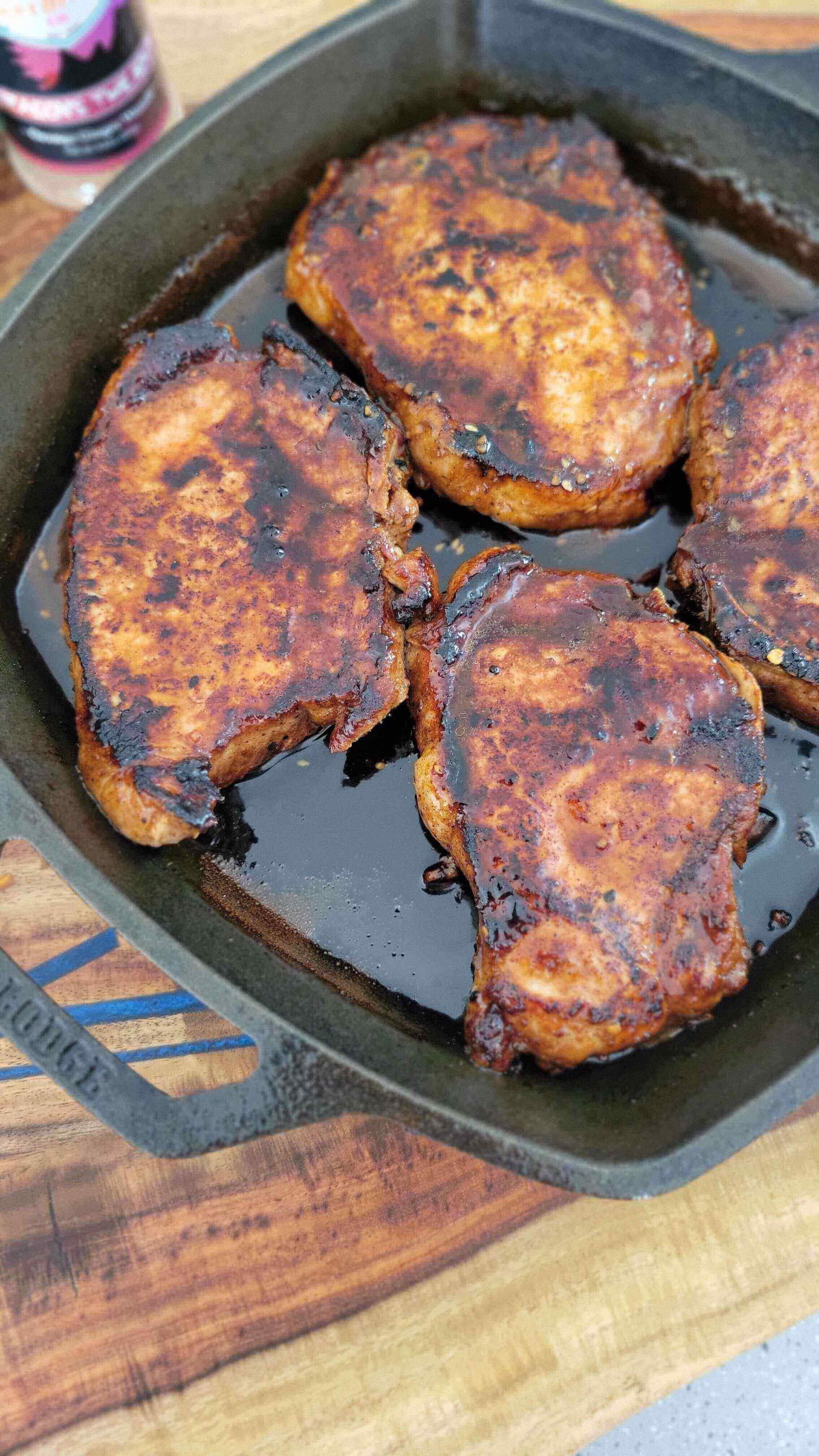 Kiss of the Dragon: Korean-Inspired Pork Chops sizzling in a cast iron skillet, showcasing a smoky, spicy glaze.
