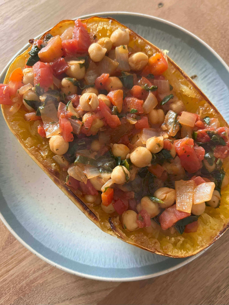 Twirl Me Tender: Tuscan Evening Spaghetti Squash filled with colorful vegetables and chickpeas, served in a plate.