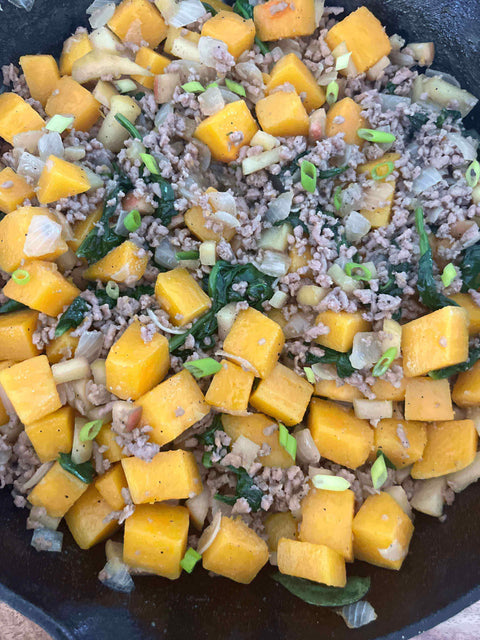 Butternut Squash Apple Sausage Hash in a skillet with diced butternut squash, ground sausage, and green onions.