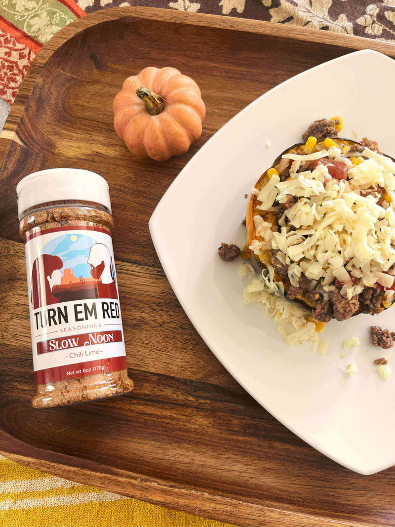 Chili Lime Acorn Squash topped with cheese and served with Slow Noon seasoning on a wooden tray.