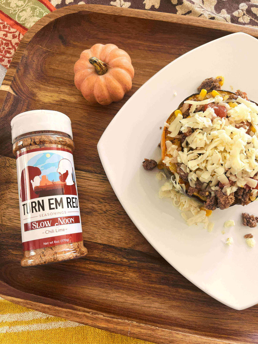 Chili Lime Acorn Squash topped with cheese and served with Slow Noon seasoning on a wooden tray.
