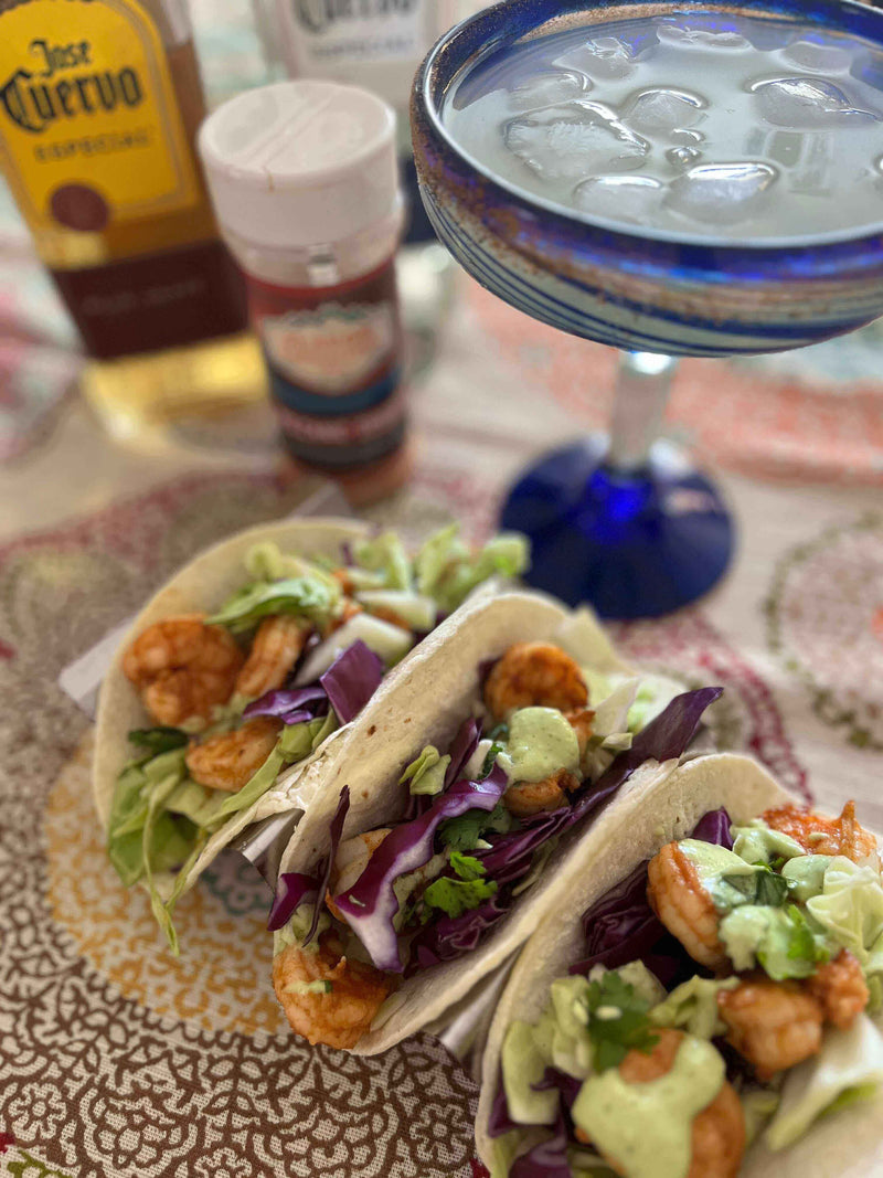 Delicious Volcanic Shrimp Tacos filled with shrimp, cabbage, and avocado next to a margarita.