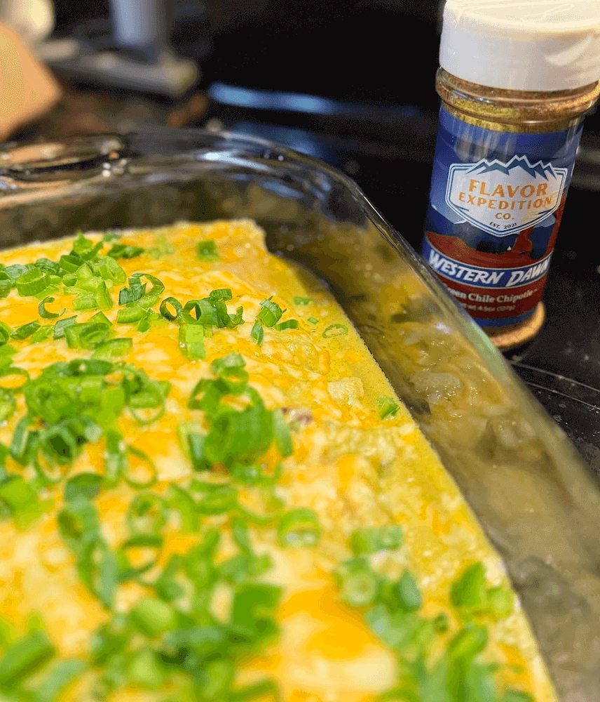 Totally Verde Enchiladas (Vegetarian) topped with green onions and Western Dawn seasoning in a baking dish.