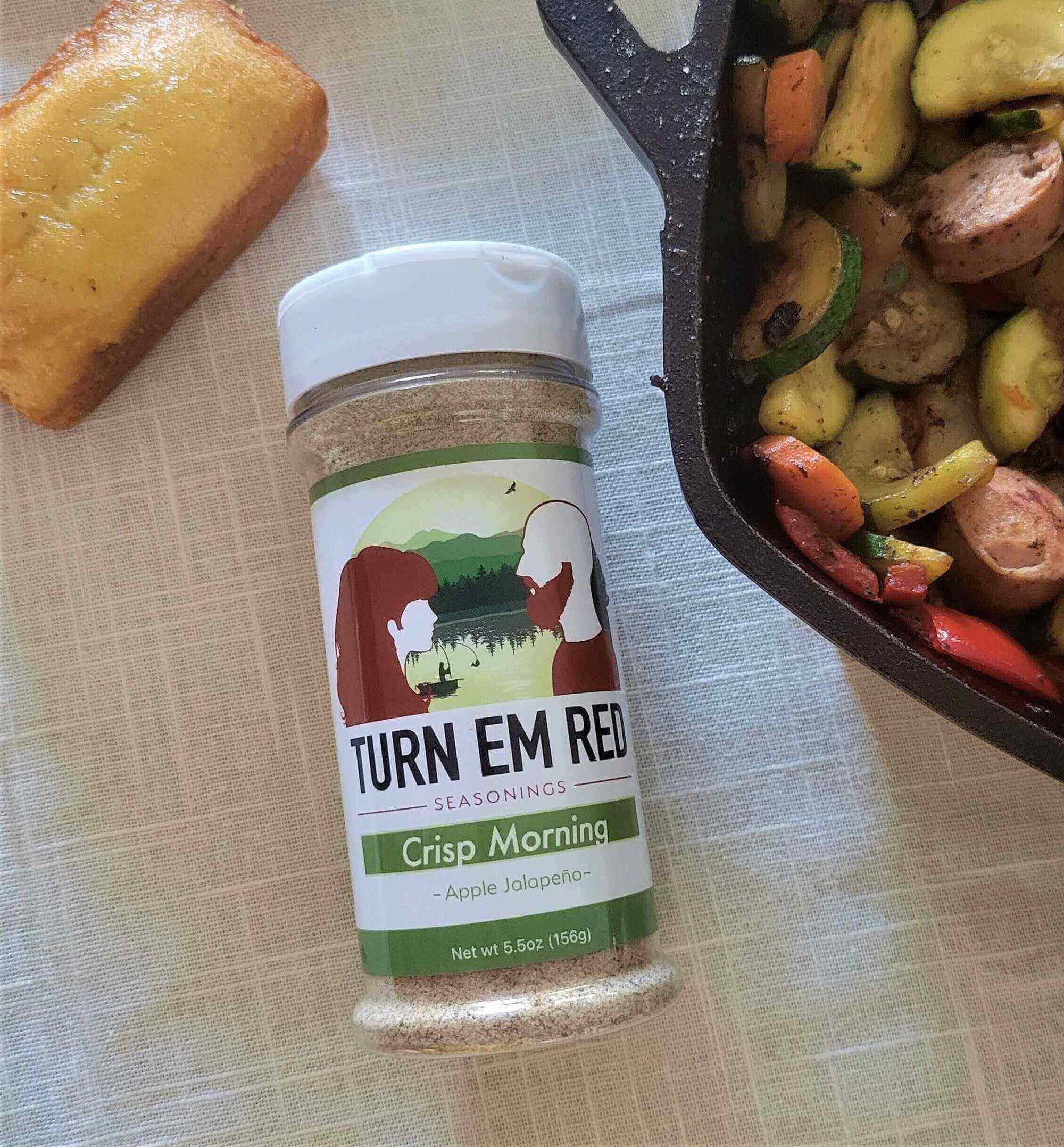 Turn Em Red Crisp Morning seasoning next to an Apple Gouda Sausage Skillet and cornbread.
