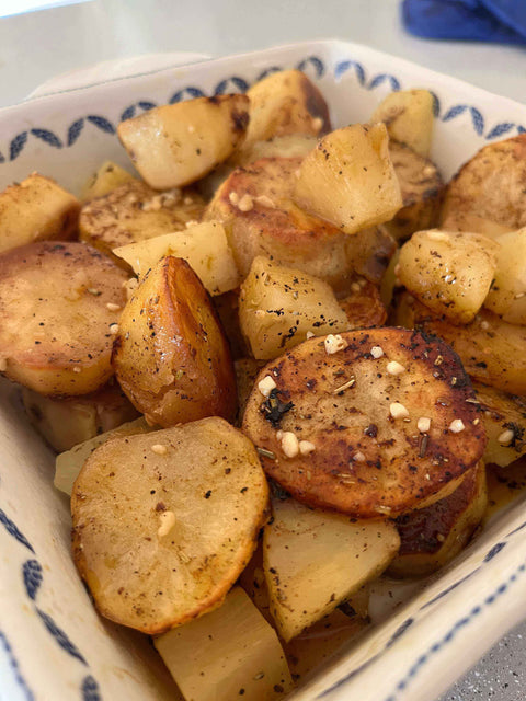 A bowl of Melting Pineapple Potatoes with golden crispy edges and tropical pineapple chunks.