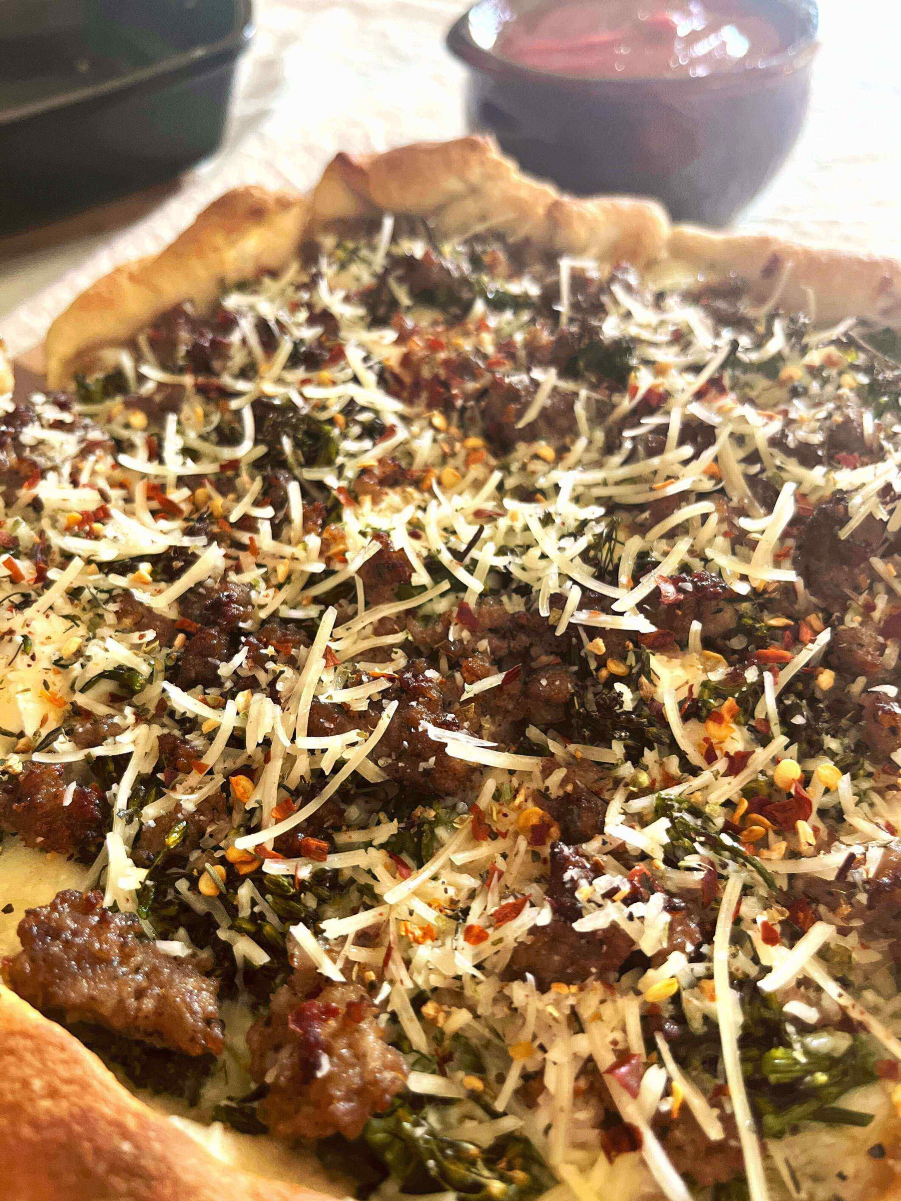 Tuscan Sunset Deep-Dish Pizza: Broccolini, Sausage & Lemon Delight topped with broccolini, sausage, and cheese.