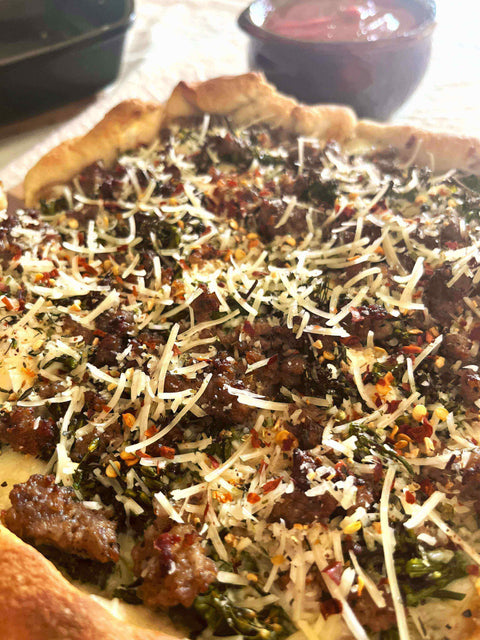 Delicious Tuscan Sunset Deep-Dish Pizza: Broccolini, Sausage & Lemon Delight topped with cheese and spices