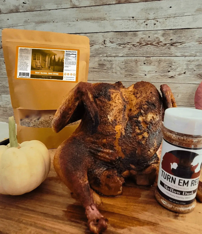 Smoked BBQ Spatchcock Chicken with spices and a pumpkin on a wooden table.