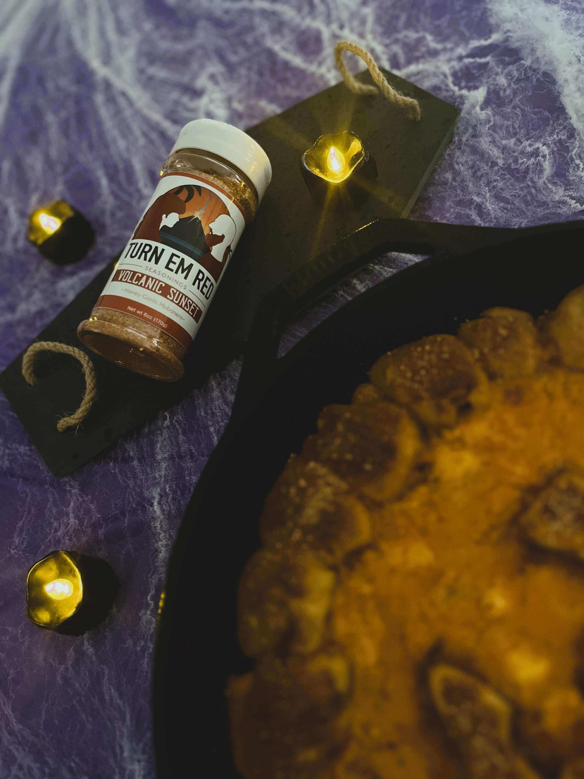 Jack O' Lantern Skillet Buffalo Chicken Dip with Volcanic Sunset seasoning and decorative candles.