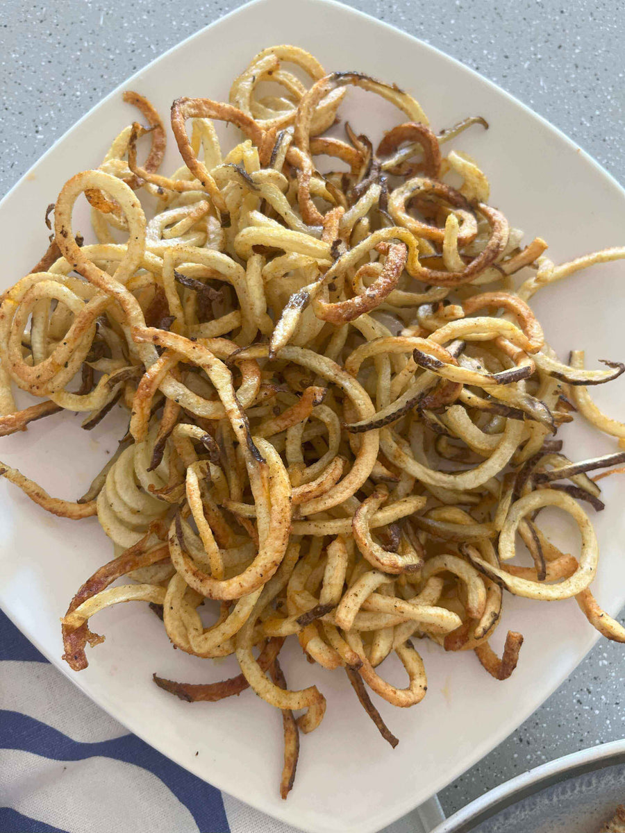 Crispy Air Fryer French Fries piled high on a plate, showcasing their golden crispy texture and curly shape.