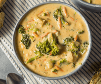 Delicious bowl of 30-Minute Broccoli Cheddar Soup, filled with fresh broccoli and carrots in creamy broth.