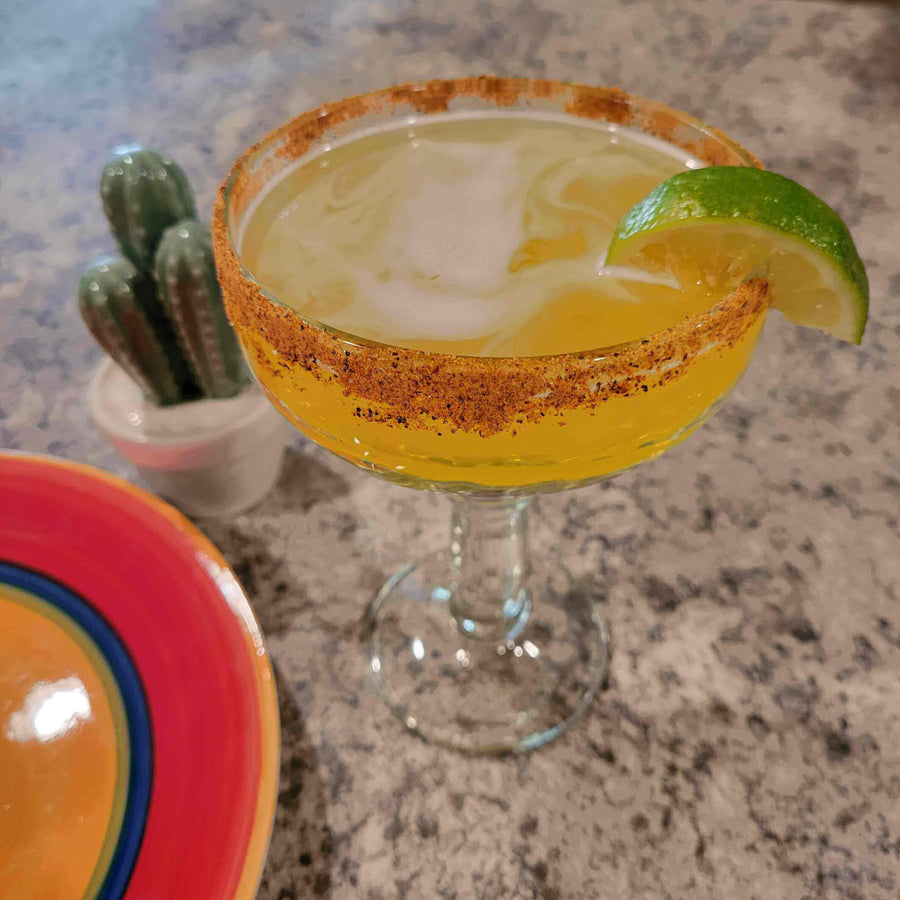 Hot Tropics Margarita served in a glass with chili-lime rim and lime wedge, perfect summer cocktail recipe.