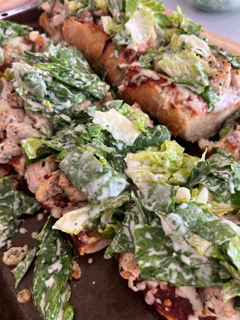 Delicious Caesar Salad French Bread Pizza topped with crunchy romaine and creamy dressing, perfect weeknight dinner recipe.