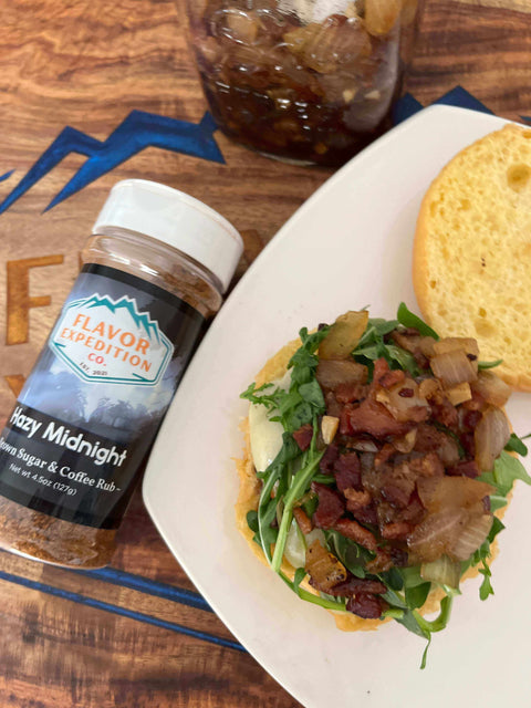 Midnight Ride Blueberry Bison Burger topped with Hazy Midnight spice mix, featuring bacon, greens, and crispy onions.