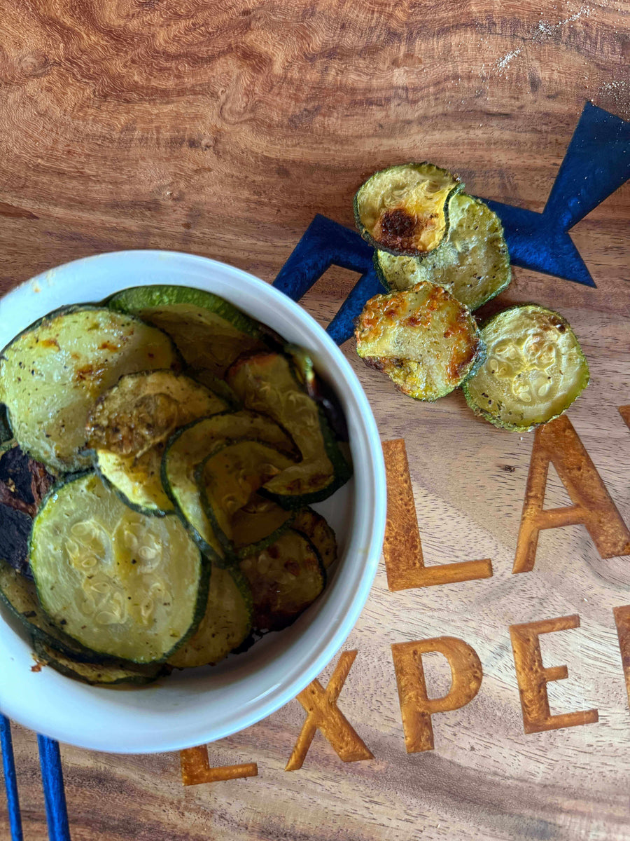 Sour Cream Onion Jalapeño Zucchini Chips in a bowl on a wooden surface, a crunchy, zesty snack.