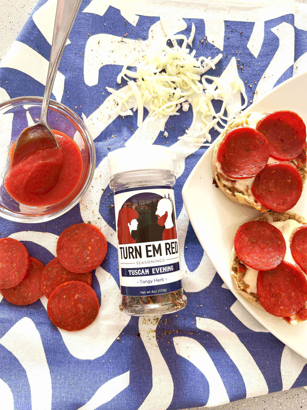 Mini Pizzas, Big Flavor: Quick English Muffin Pizzas with pepperoni and seasoning on a colorful tablecloth.