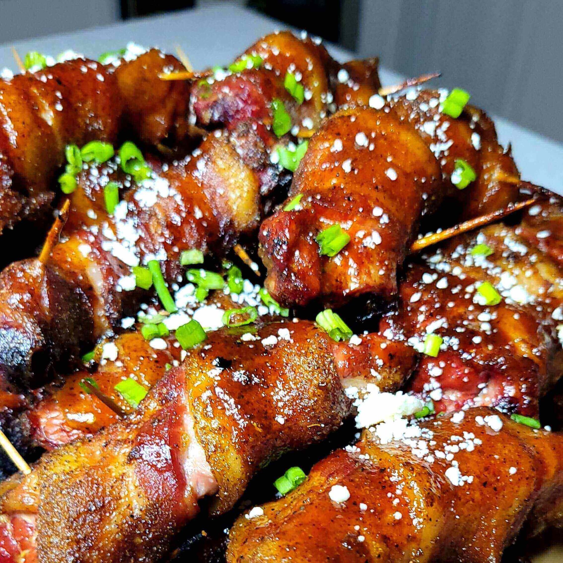 Bacon-Wrapped Ribs: The Porky Showstopper stacked with green onions and seasoning, ready to be devoured.
