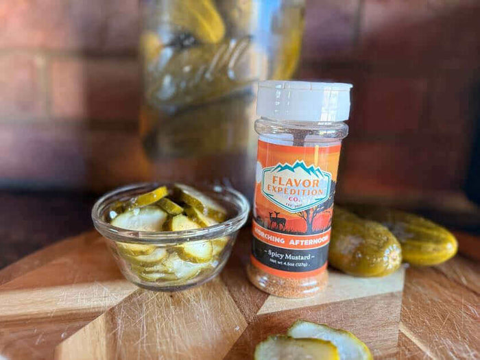 Pickle Me, Baby, One More Time: Homemade Spicy Mustard Pickles in a jar and seasoning spice bottle on a wooden board.