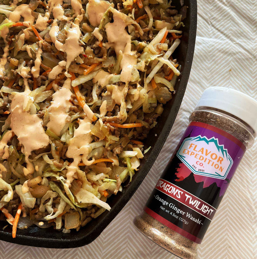 Fire-Breathing Egg Roll in a Bowl topped with sauce next to Dragons Twilight Orange Ginger Wasabi seasoning.