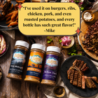 Three bottles of Flavor Expedition seasoning with cooked meats and sides on a wooden table.