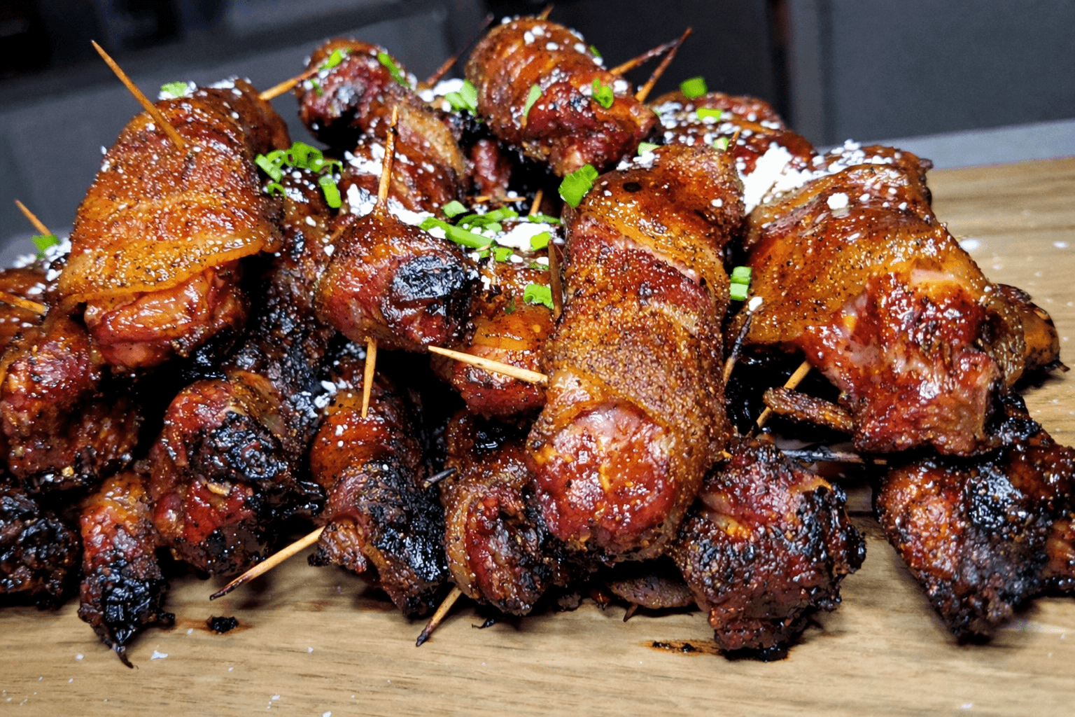 Bacon-wrapped meat skewers on a wooden board
