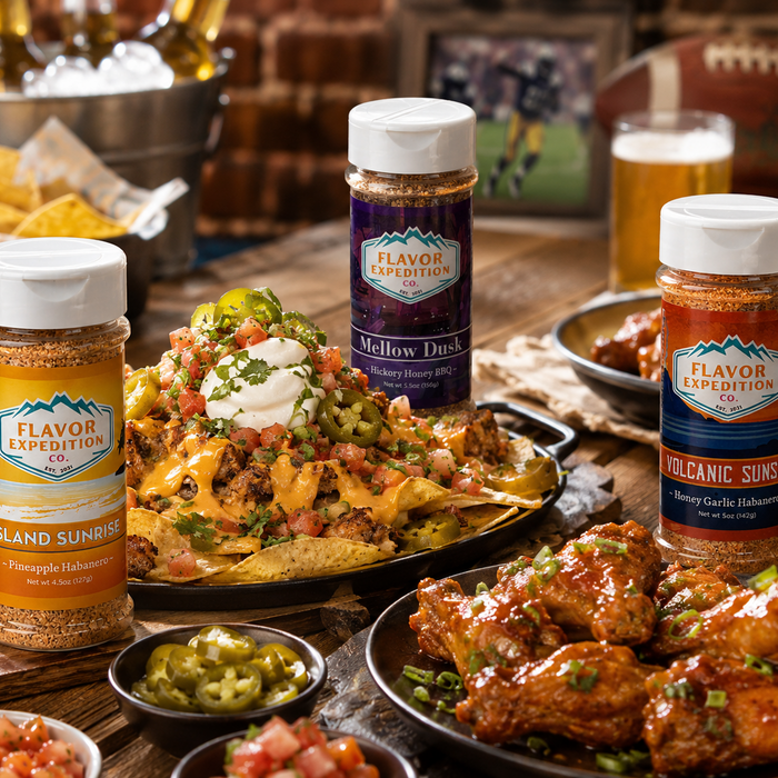 Plates of food with Flavor Expedition seasoning bottles on a table.