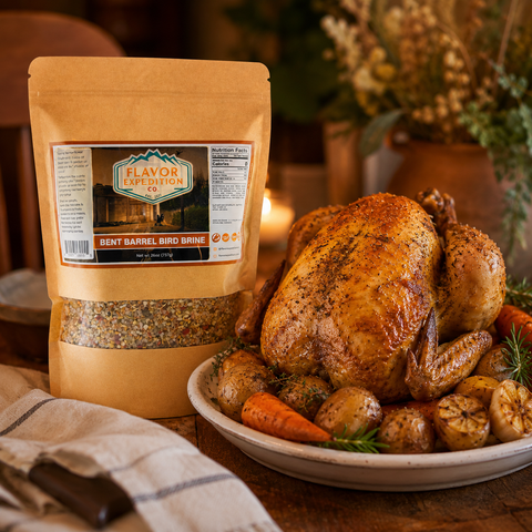 Roasted chicken with carrots and potatoes on a plate next to a package of 'Flavor Expedition' brine.