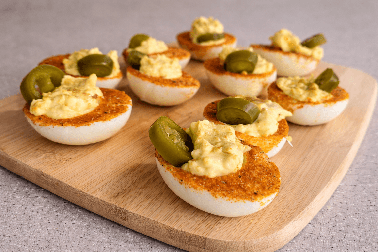 Deviled eggs with pickles on a wooden board