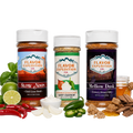 Three spice seasoning bottles from Flavor Expedition Co. are displayed on a white background with their corresponding flavor ingredients arranged around them.