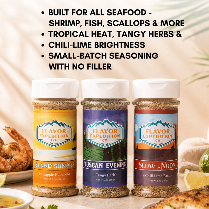 Three seasoning jars with labels 'Island Sunrise', 'Tuscan Evening', and 'Slow Noon' from Flavor Expedition Co. on a table with food.