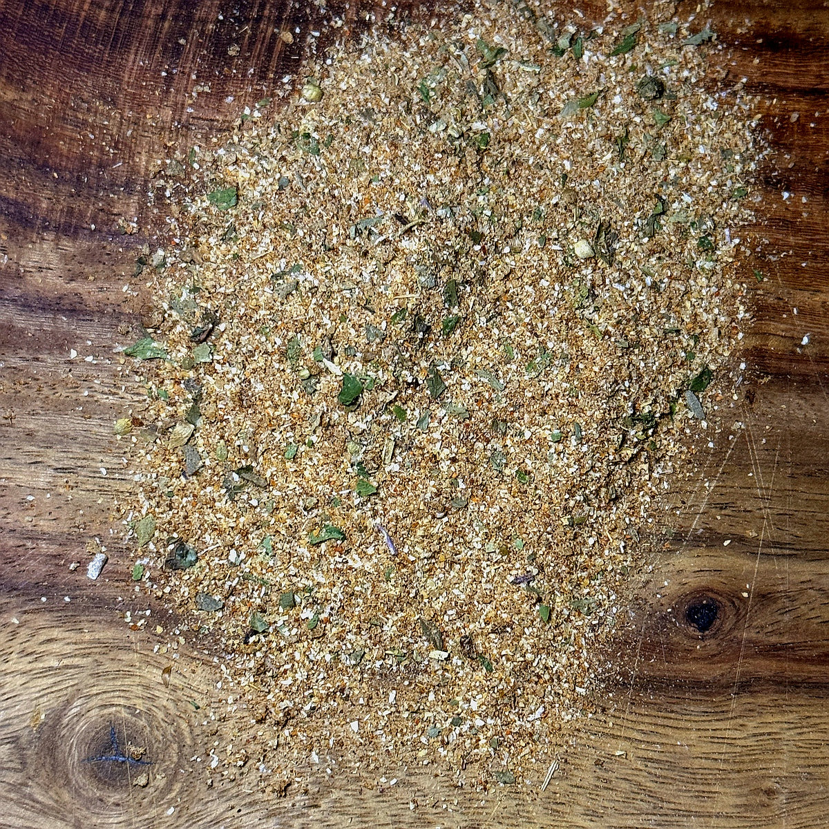 Spicy Citrus Cilantro Seasoning scattered on a wooden surface, showcasing its vibrant blend of spices and herbs.