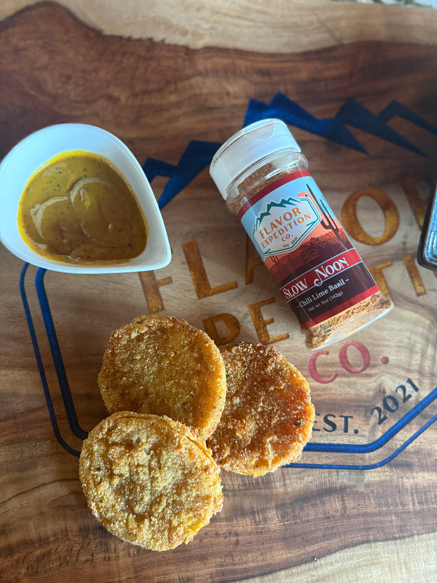Crispy fried pickles served with dipping sauce and seasoning from Flavor Republic on a wooden platter.