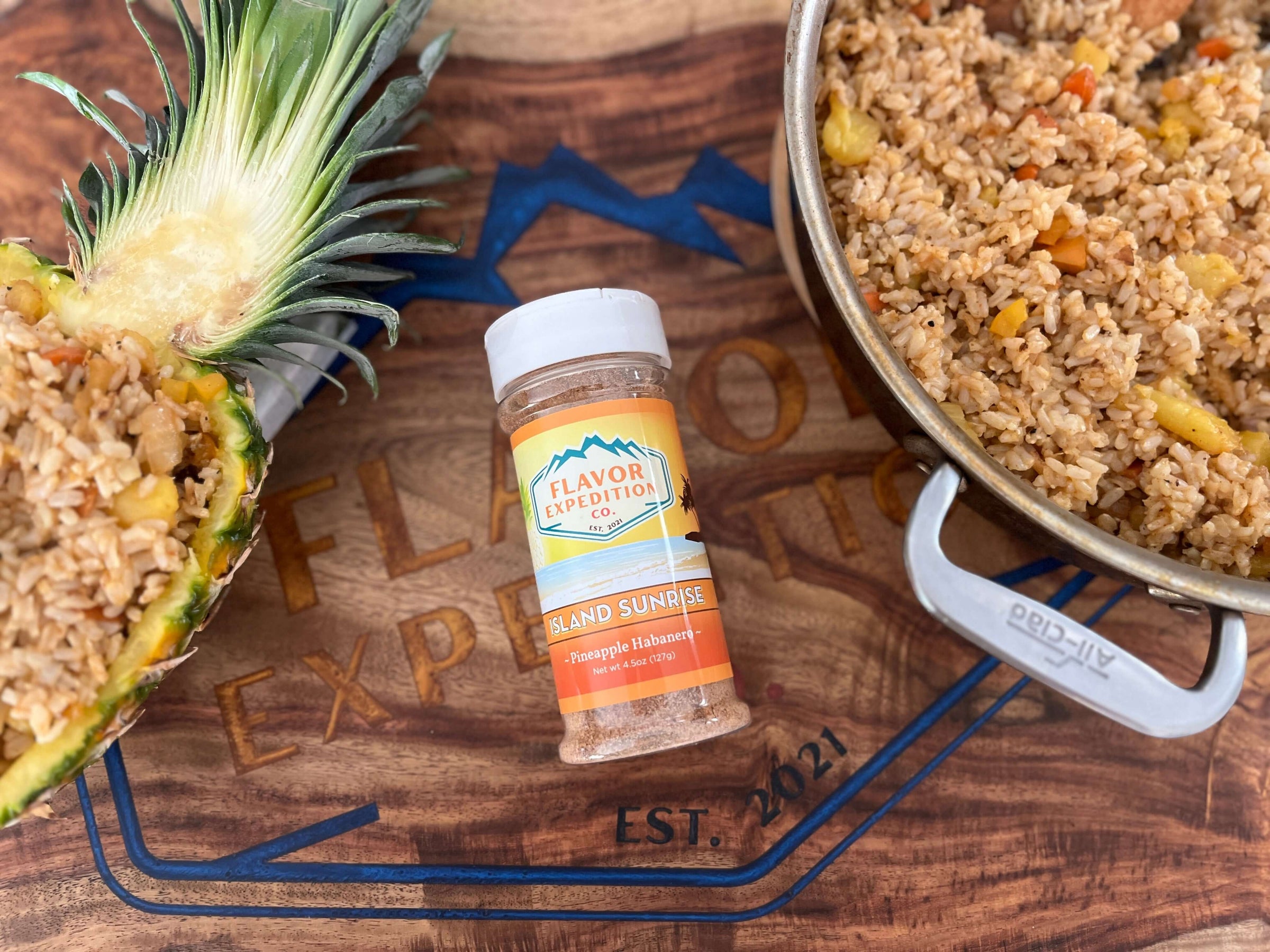 Pineapple and flavorful rice dish with 'Island Sunrise' seasoning from Flavor Expedition on a wooden board.