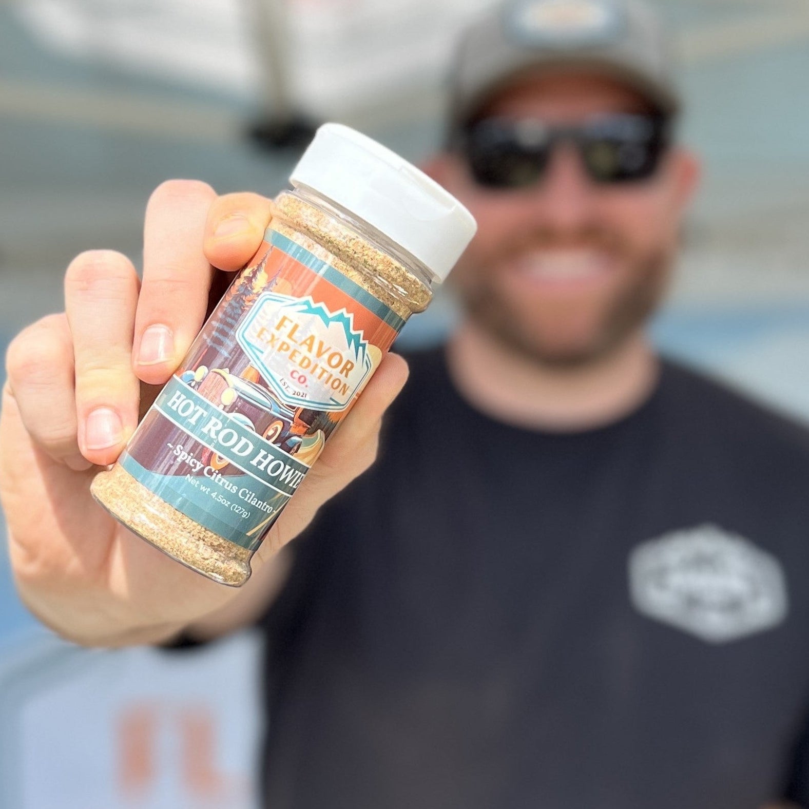 Person holding a jar of 'Hot Rod Howie's" with a blurred background