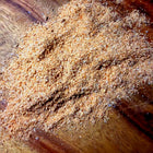 Close-up of a wooden surface with a pile of brown powder.