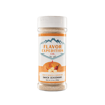 Spicy White Cheddar snack seasoning container with 'Flavor Expedition Co.' label on a white background