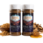 Two jars of 'Mellow Dusk' Hickory Honey BBQ seasoning from Flavor Expedition Co. with ingredients around on a white background.