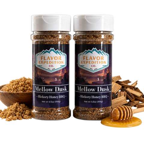 Two jars of 'Mellow Dusk' Hickory Honey BBQ seasoning from Flavor Expedition Co. with ingredients around on a white background.