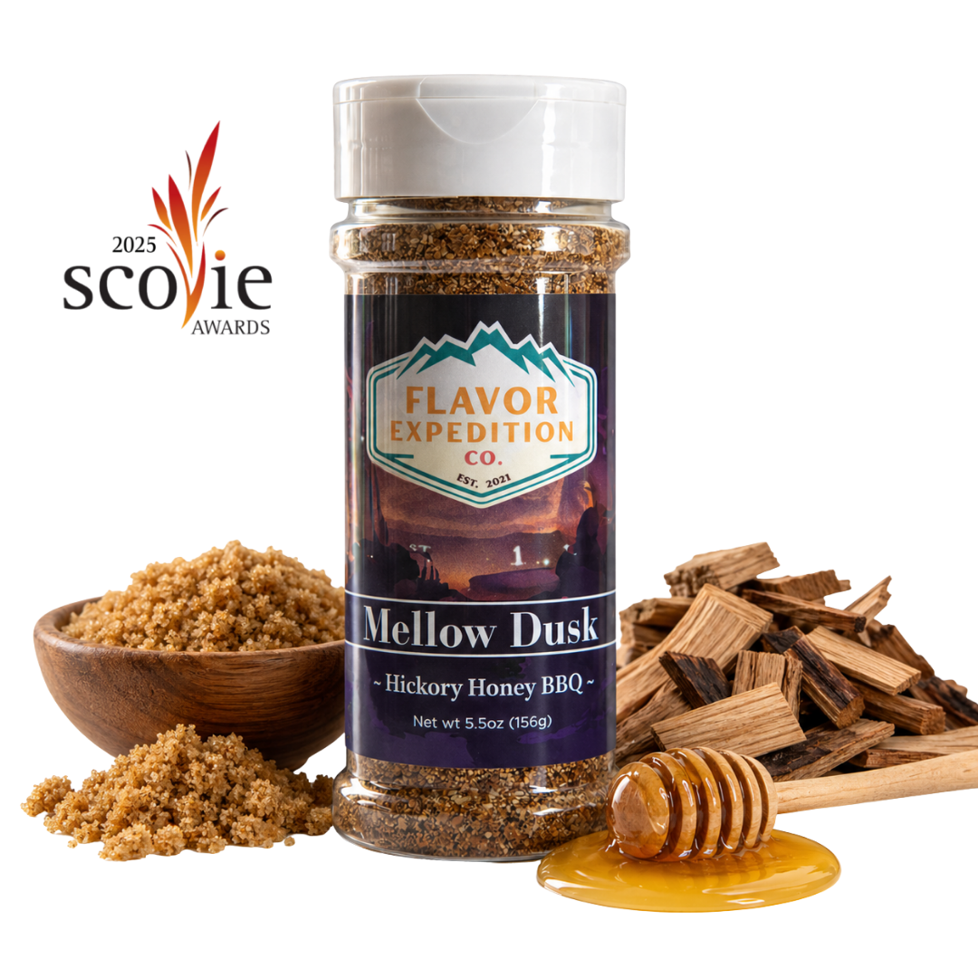 A bottle of Flavor Expedition Co. Mellow Dusk Hickory Honey BBQ seasoning stands centered on a white background, surrounded by ingredients including a wooden bowl of brown sugar, wood chips, and a honey dipper with honey. [pack-1]