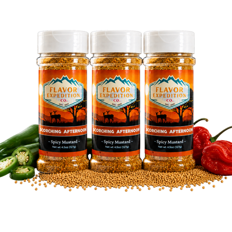 Three bottles of Flavor Expedition Co. Spicy Mustard with peppers and mustard seeds on a black background