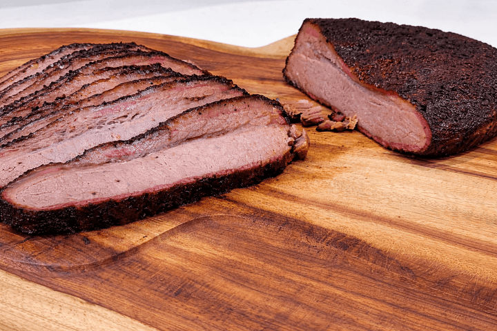 Sliced smoked meat on a wooden cutting board