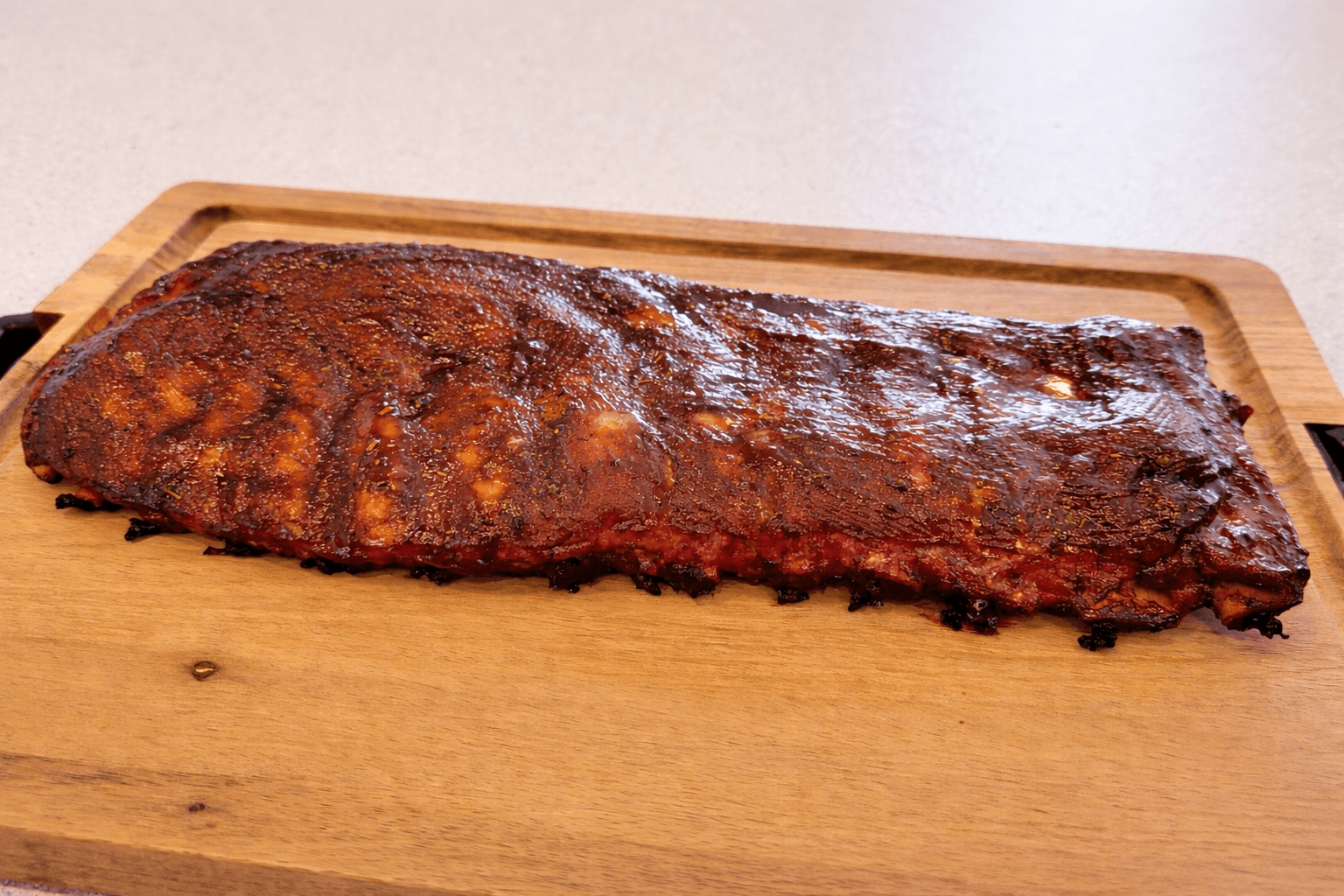 Barbecue ribs on a wooden cutting board with a white background
