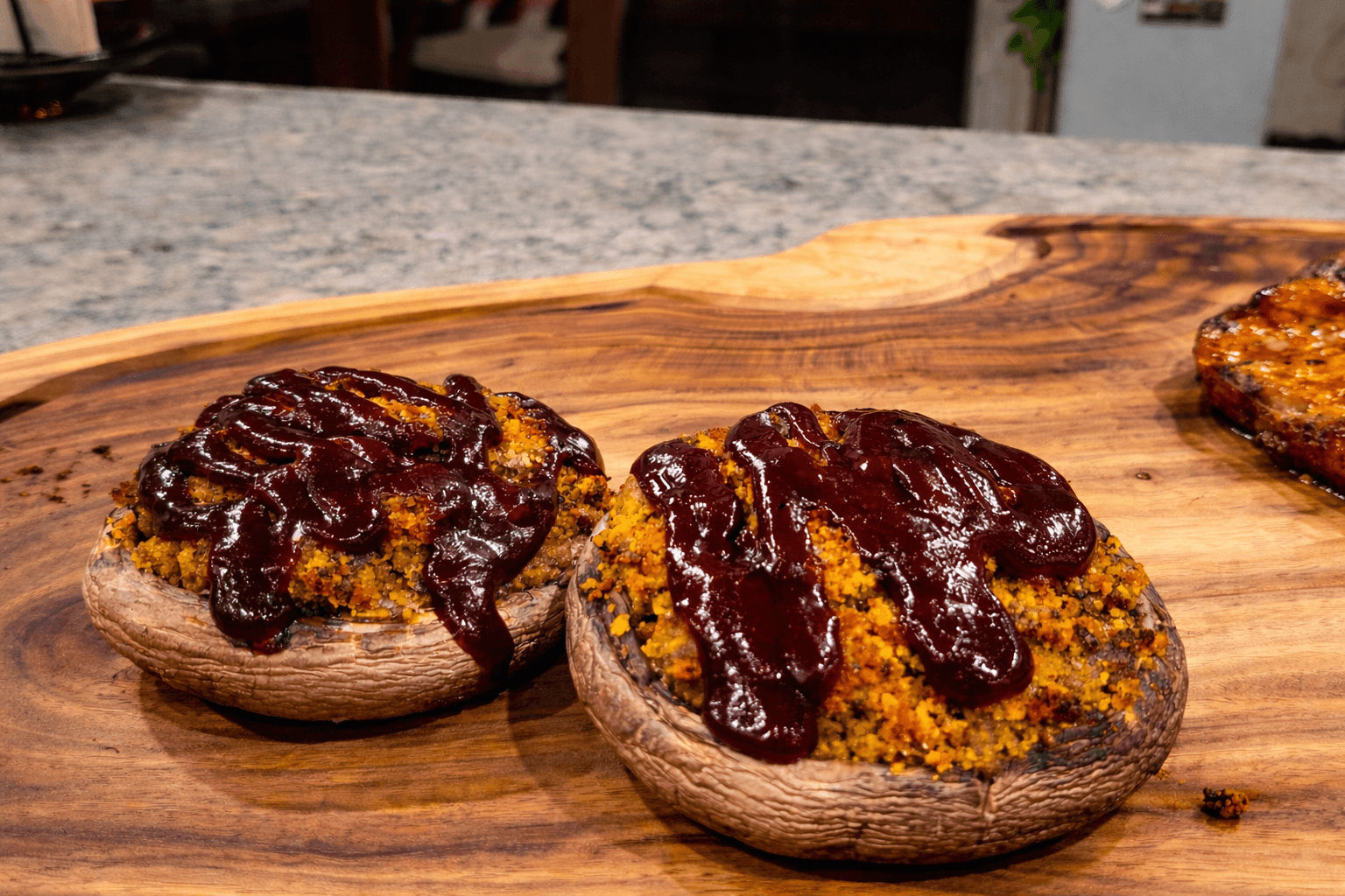 stuffed mushrooms with bbq sauce on a wood cutting board