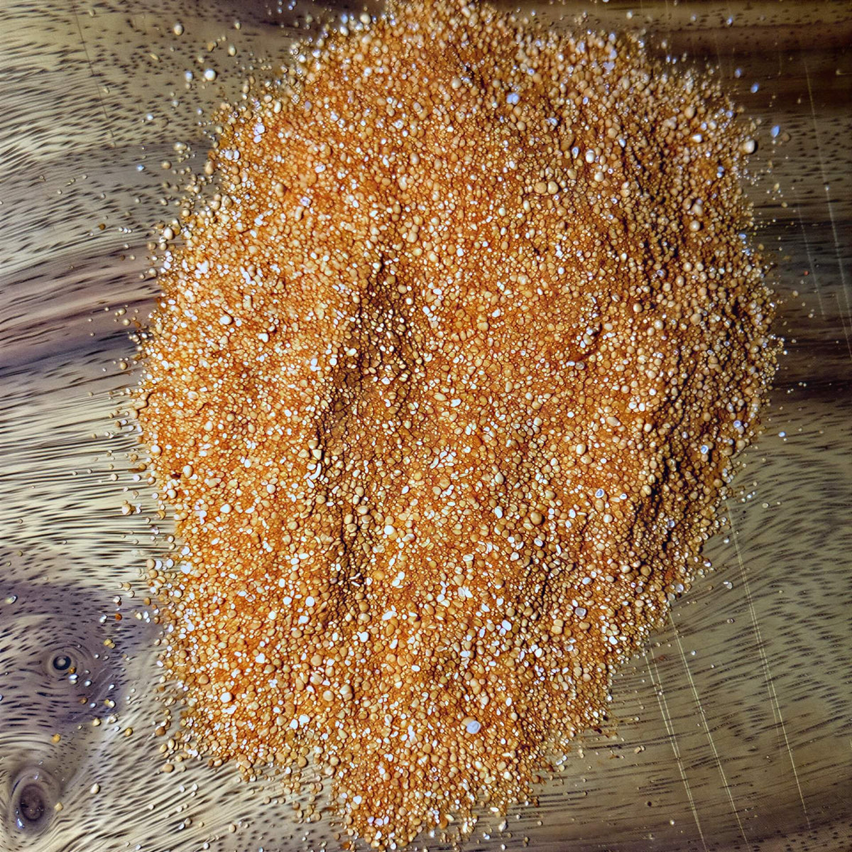 Honey Garlic Habanero Seasoning pile on a wooden surface, showcasing its vibrant color and texture.