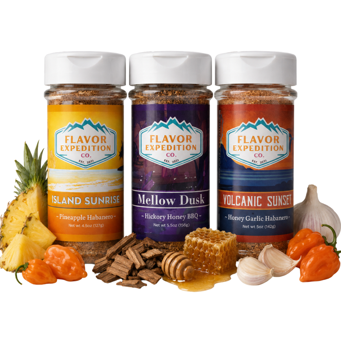 Three jars of Flavor Expedition Co. spices with ingredients like pineapple, garlic, and peppers on a white background.