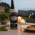 Tangy Herb Seasoning - Tuscan Evening displayed with pasta, candles, and fresh herbs in a scenic outdoor setting.